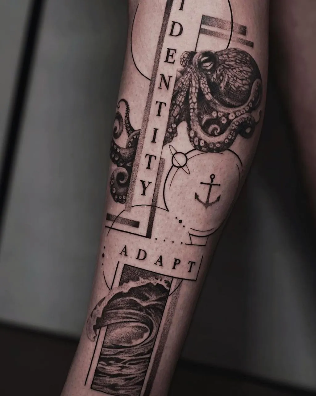 Forearm tattoo of an octopus with an anchor, a wave panel and lettering.