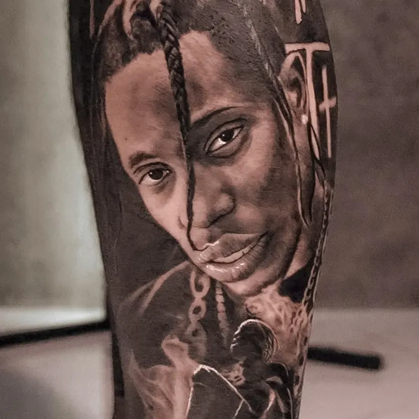 Close-up of a black and grey realism portrait tattoo of a person with braided hair.