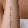 Fine line script forearm tattoo reading lucky enough