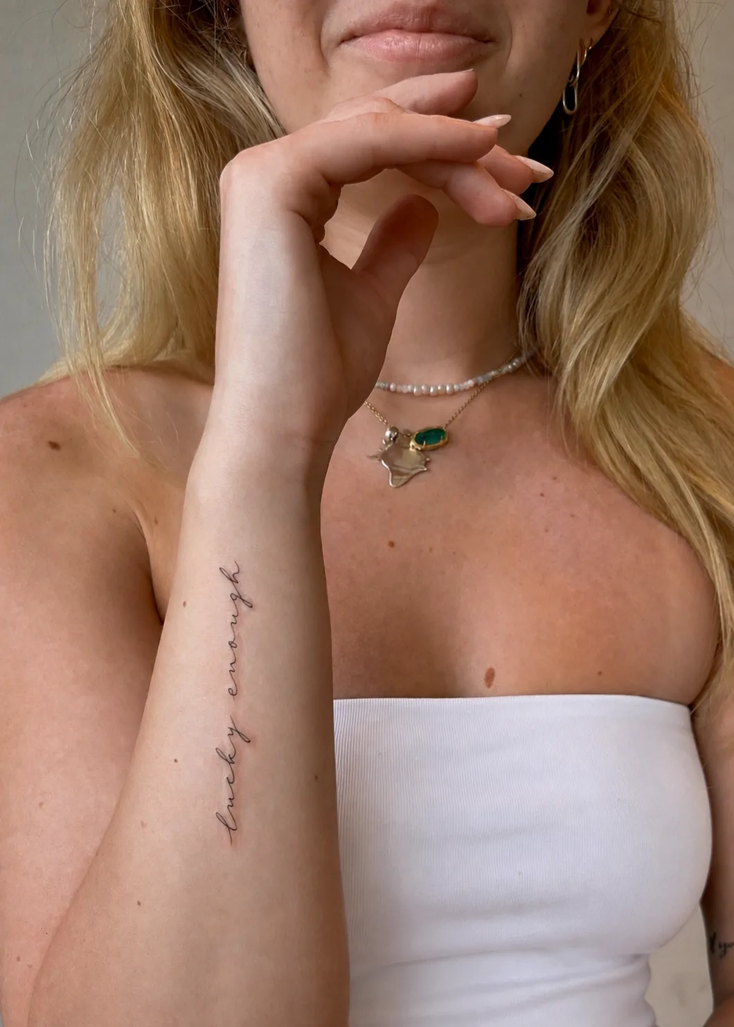Fine line script forearm tattoo reading lucky enough